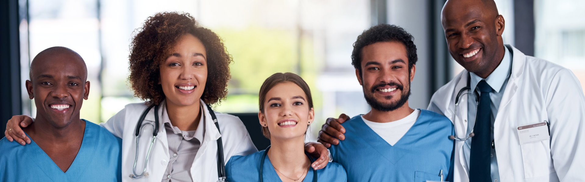 group and doctors with embrace, healthcare and collaboration with interns, smile and hospital